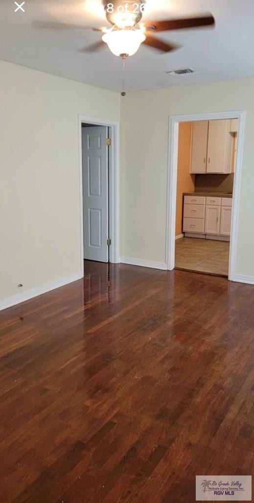 empty room featuring dark wood-type flooring and ceiling fan