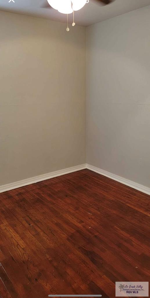 unfurnished room with dark wood-type flooring