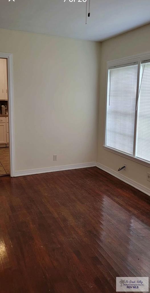 empty room featuring dark wood-type flooring and ceiling fan