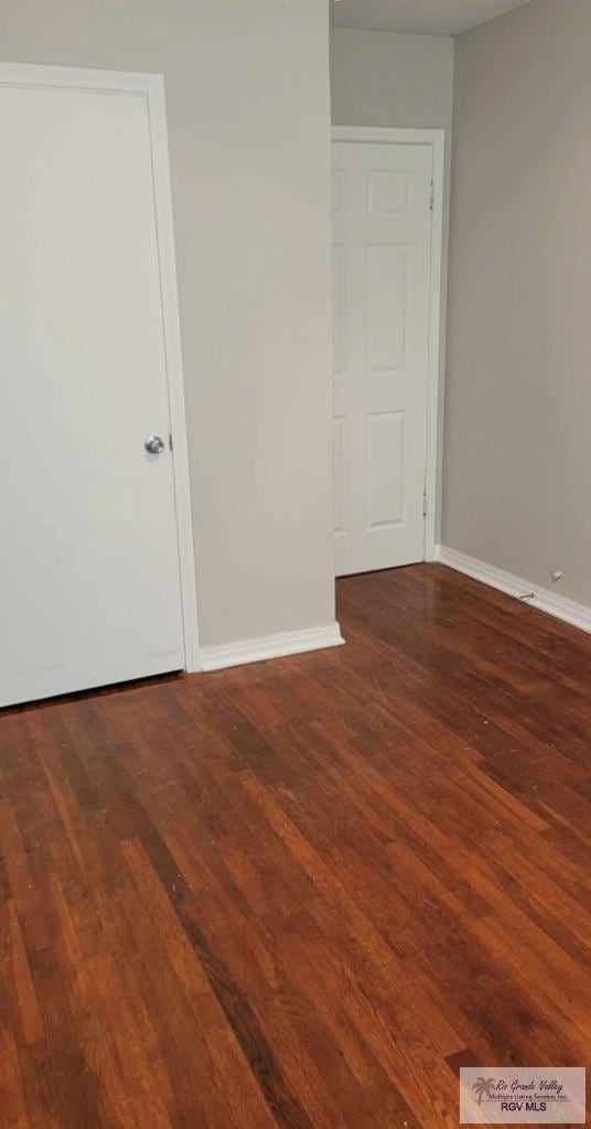 unfurnished room featuring dark wood-type flooring