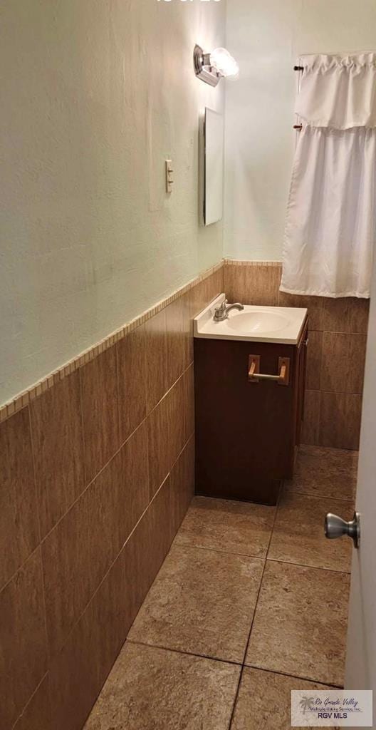 bathroom featuring vanity, tile patterned floors, and tile walls