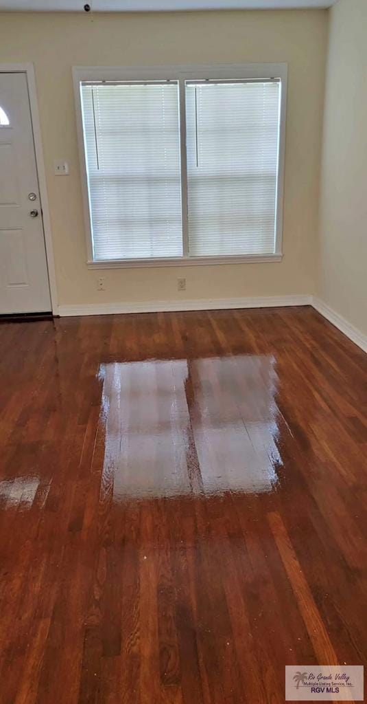 unfurnished room with dark wood-type flooring