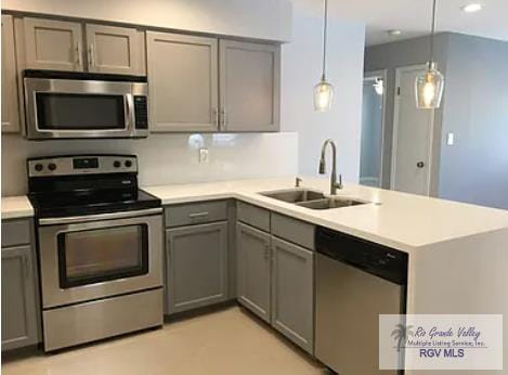 6212 NW King Arthur Ct, Harlingen, TX 78550 - kitchen with stainless steel appliances, gray cabinets, a sink, a peninsula, and light countertops