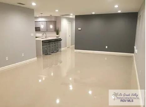 6212 NW King Arthur Ct, Harlingen, TX 78550 - unfurnished living room featuring recessed lighting, baseboards, and a sink