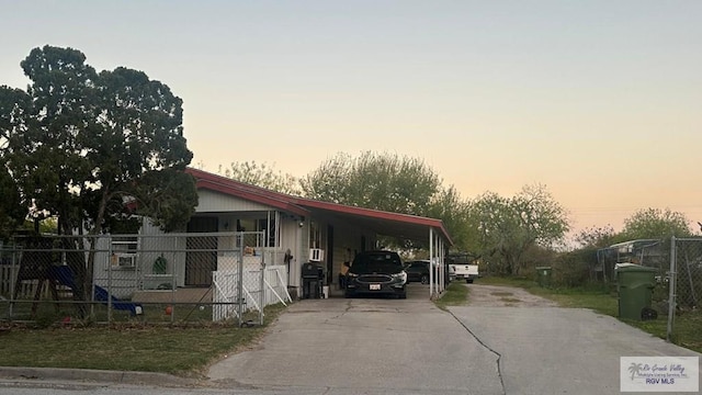 view of front of property with a carport, driveway, and fence