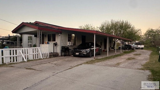 view of front of house featuring a carport, fence, and driveway