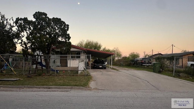 view of front of home with a carport, fence, and driveway