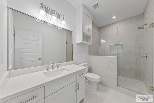 full bathroom with tile patterned flooring, toilet, vanity, visible vents, and a shower stall