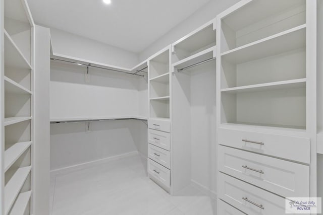 walk in closet with light tile patterned floors