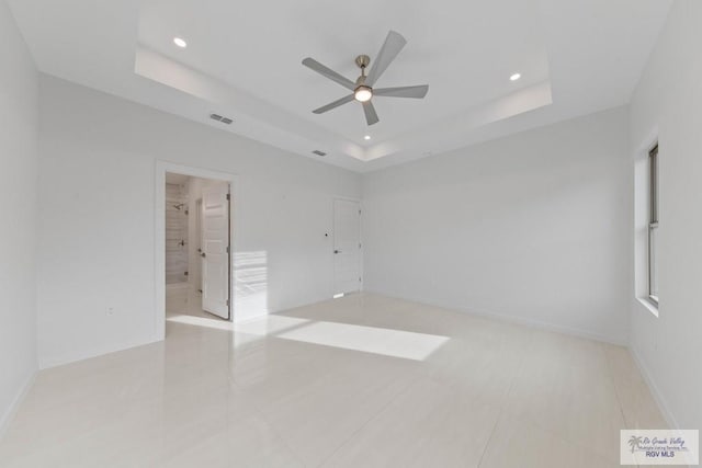 empty room featuring ceiling fan, recessed lighting, visible vents, baseboards, and a raised ceiling