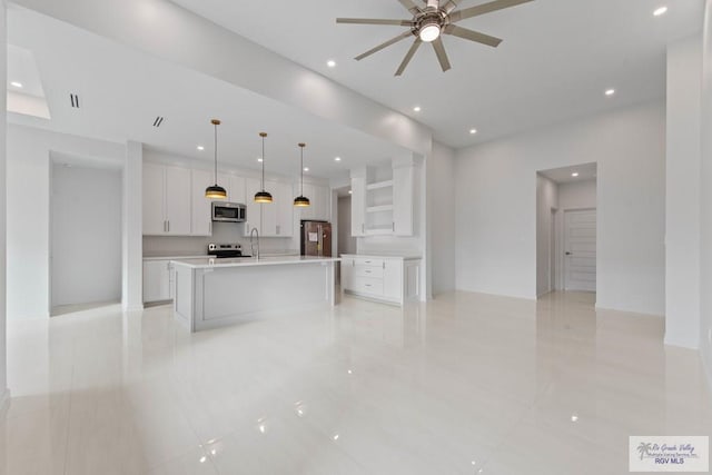 kitchen featuring white cabinetry, appliances with stainless steel finishes, light countertops, and pendant lighting