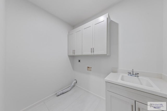 laundry room with cabinet space, baseboards, electric dryer hookup, washer hookup, and a sink