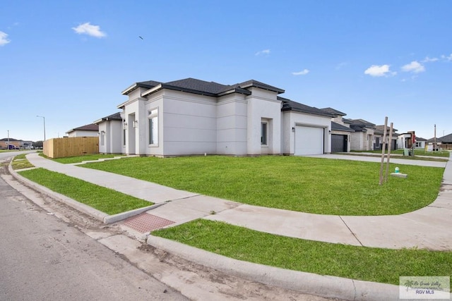 view of side of home featuring a garage, fence, concrete driveway, a lawn, and a residential view