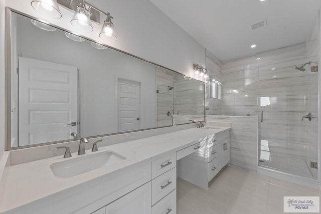 bathroom featuring double vanity, a stall shower, a sink, and visible vents