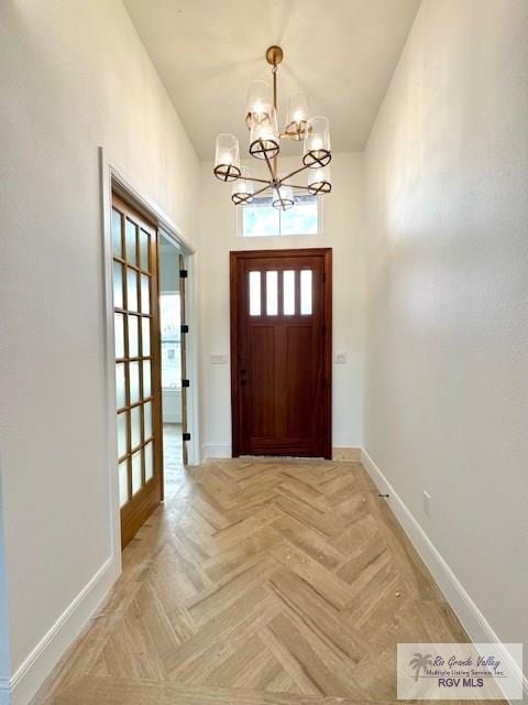 doorway to outside featuring light parquet flooring and a chandelier