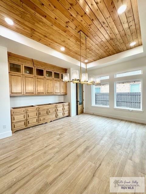 kitchen with a raised ceiling, pendant lighting, wooden ceiling, and light hardwood / wood-style floors