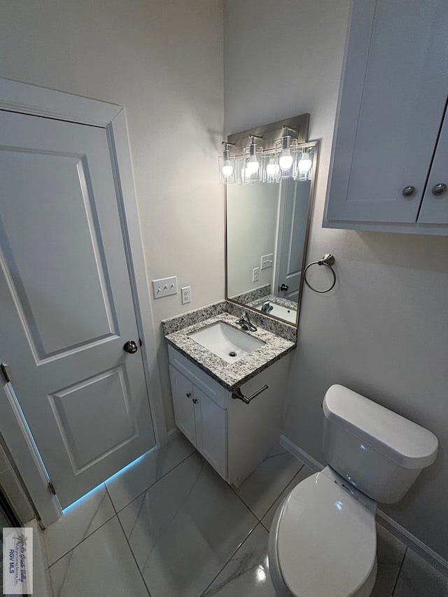 bathroom featuring tile patterned flooring, vanity, and toilet