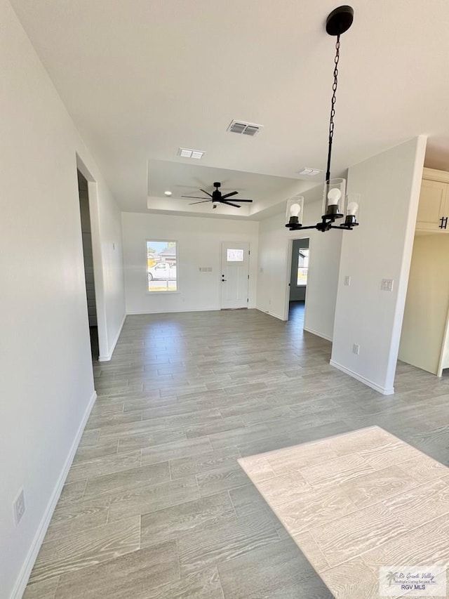 unfurnished living room with light hardwood / wood-style floors and ceiling fan with notable chandelier