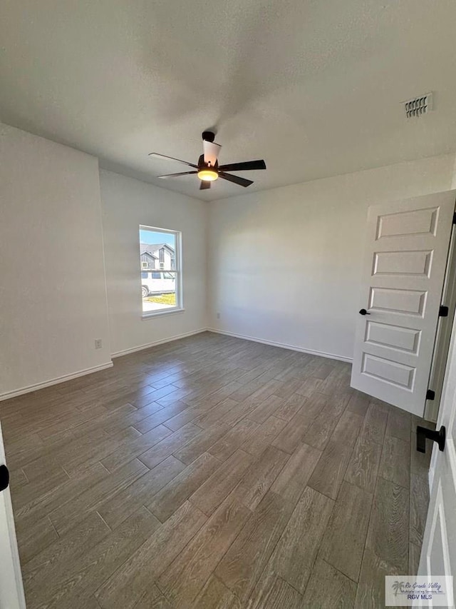 spare room featuring ceiling fan, dark hardwood / wood-style flooring, and a textured ceiling