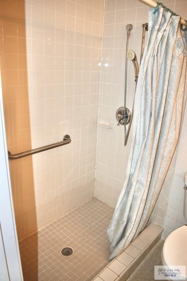 bathroom featuring a shower with curtain and toilet