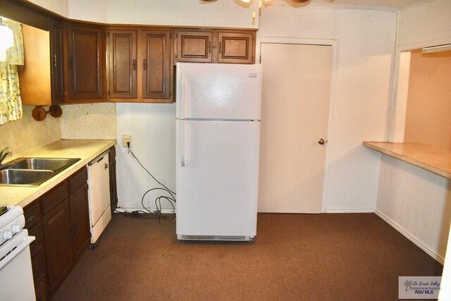 kitchen featuring white appliances, ceiling fan, a sink, light countertops, and dark carpet