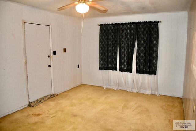 carpeted spare room with a ceiling fan