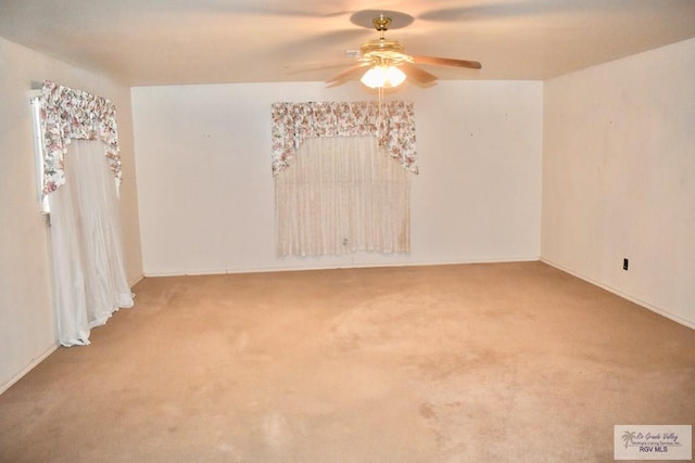 carpeted spare room featuring ceiling fan