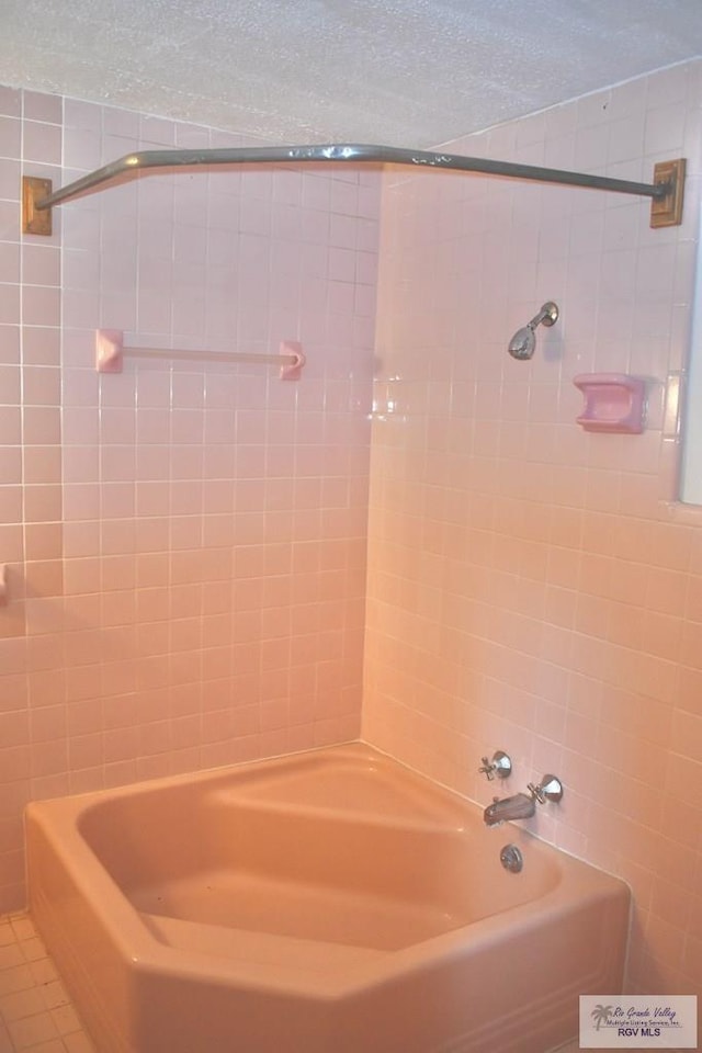 bathroom featuring tile patterned flooring, a textured ceiling, and tiled shower / bath combo