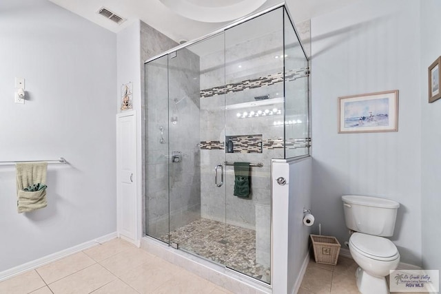 bathroom featuring tile patterned flooring, toilet, and walk in shower