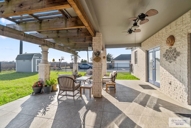 view of patio / terrace with ceiling fan, a shed, and french doors