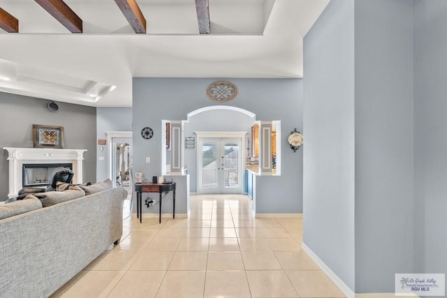 entryway with beamed ceiling, light tile patterned flooring, and french doors