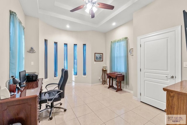 office area with ceiling fan, a tray ceiling, and light tile patterned floors