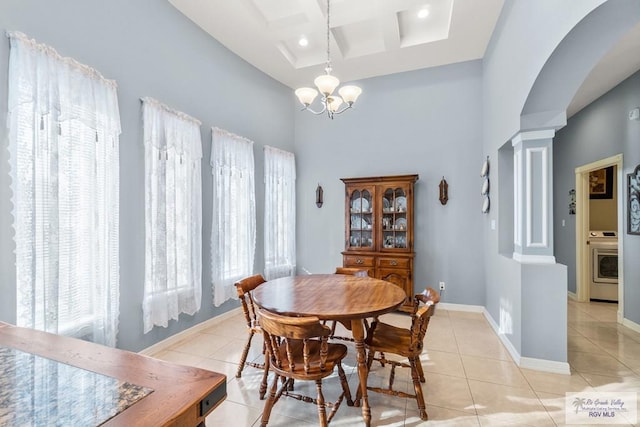 dining space with light tile patterned floors, coffered ceiling, washer / clothes dryer, a chandelier, and ornate columns