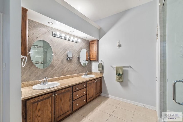 bathroom with a shower with door, vanity, and tile patterned floors