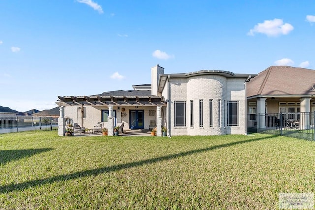 rear view of house with a pergola, a patio area, and a lawn