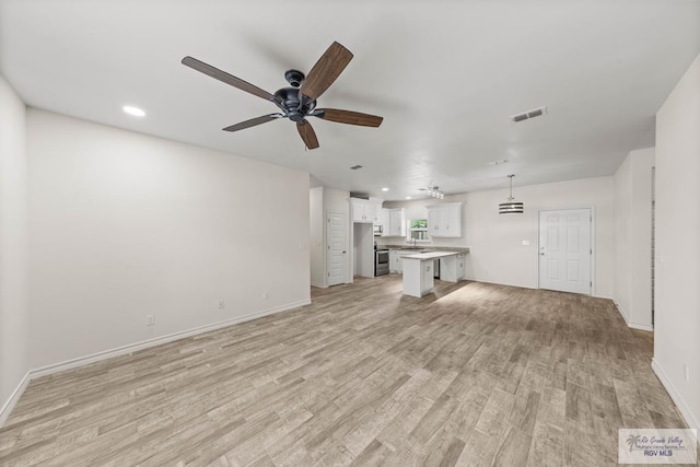 unfurnished living room with ceiling fan and light hardwood / wood-style flooring