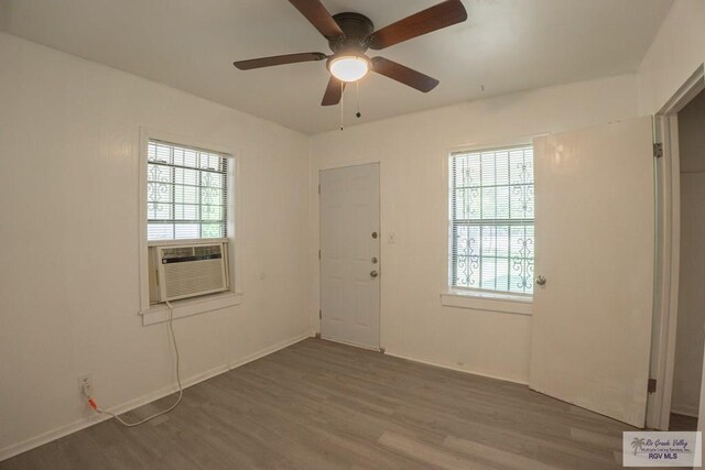 spare room featuring ceiling fan, hardwood / wood-style floors, and cooling unit