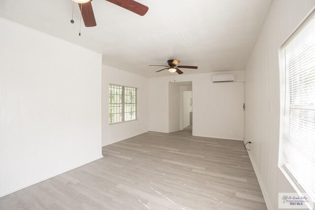 spare room featuring ceiling fan, light hardwood / wood-style floors, and an AC wall unit