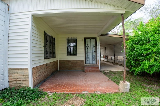 view of exterior entry with a carport