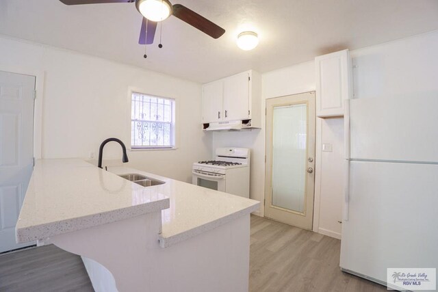 kitchen featuring white appliances, sink, kitchen peninsula, light hardwood / wood-style floors, and white cabinetry