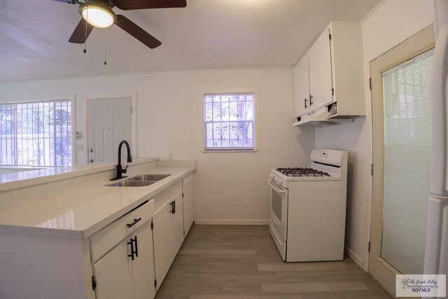 kitchen featuring sink, light stone counters, light hardwood / wood-style floors, white range with gas cooktop, and white cabinets