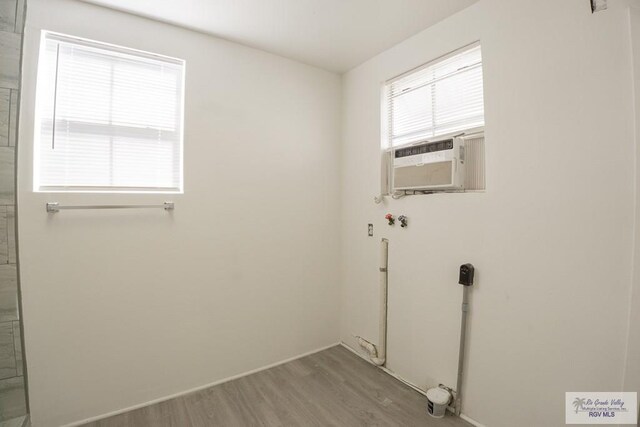 washroom featuring washer hookup, light hardwood / wood-style flooring, and cooling unit