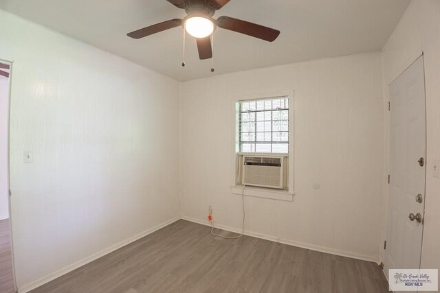 unfurnished room featuring hardwood / wood-style flooring, cooling unit, and ceiling fan