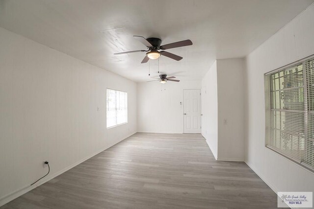 empty room with ceiling fan and light hardwood / wood-style floors