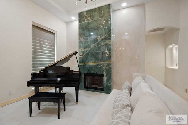 misc room with light tile patterned flooring and a high end fireplace