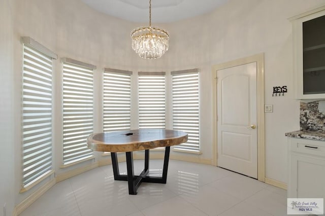 tiled dining space with a wealth of natural light and a notable chandelier