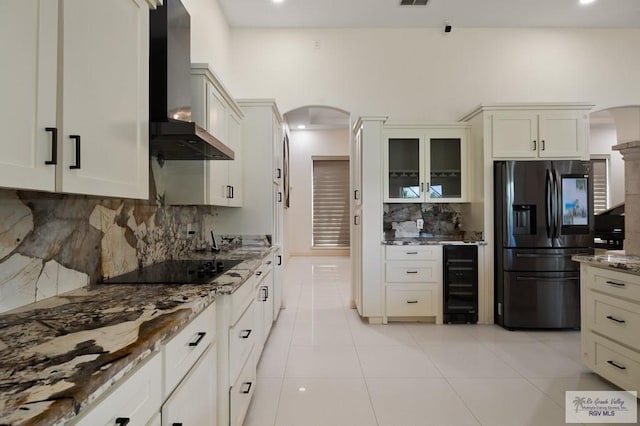 kitchen with decorative backsplash, wall chimney range hood, fridge with ice dispenser, and wine cooler