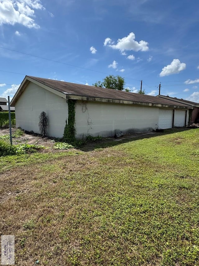 2605 Wilson Rd, Harlingen, TX 78552 - view of side of home with a yard and an attached garage