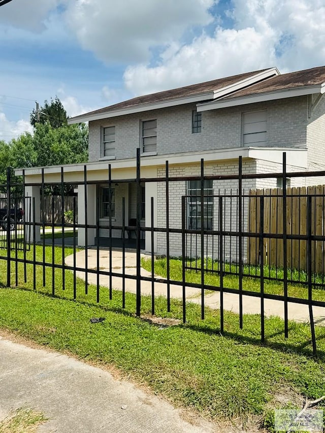 2605 Wilson Rd, Harlingen, TX 78552 - rear view of house featuring brick siding and a fenced front yard