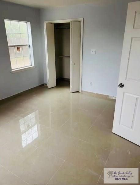 2605 Wilson Rd, Harlingen, TX 78552 - unfurnished bedroom featuring tile patterned flooring and a closet